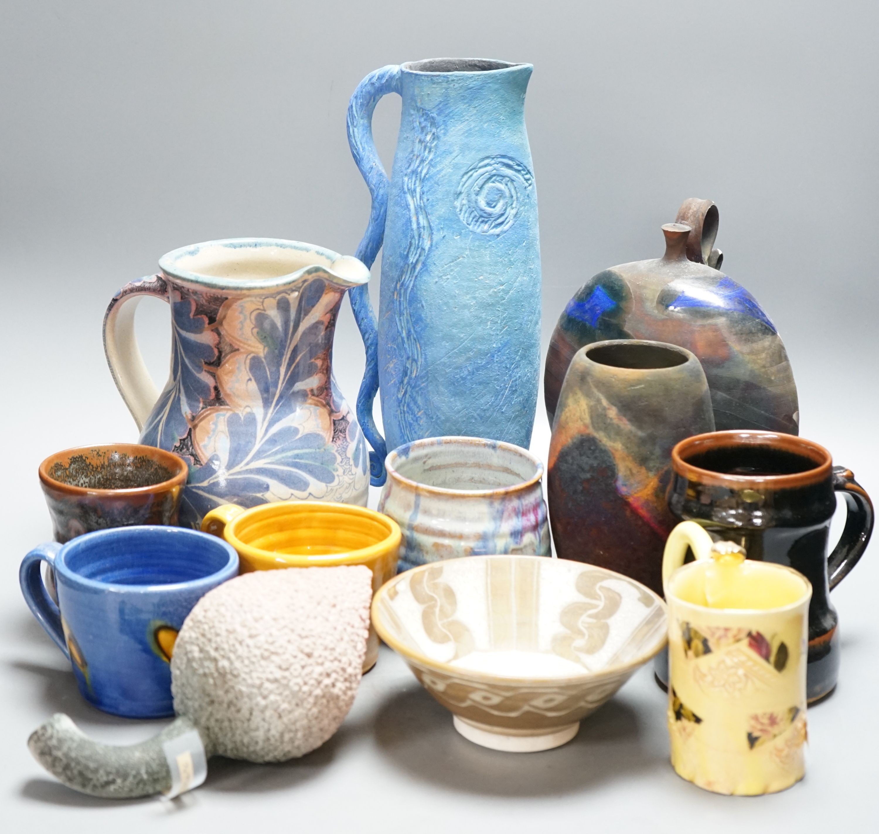 A group of studio pottery jugs, mugs, and other vessels to include –